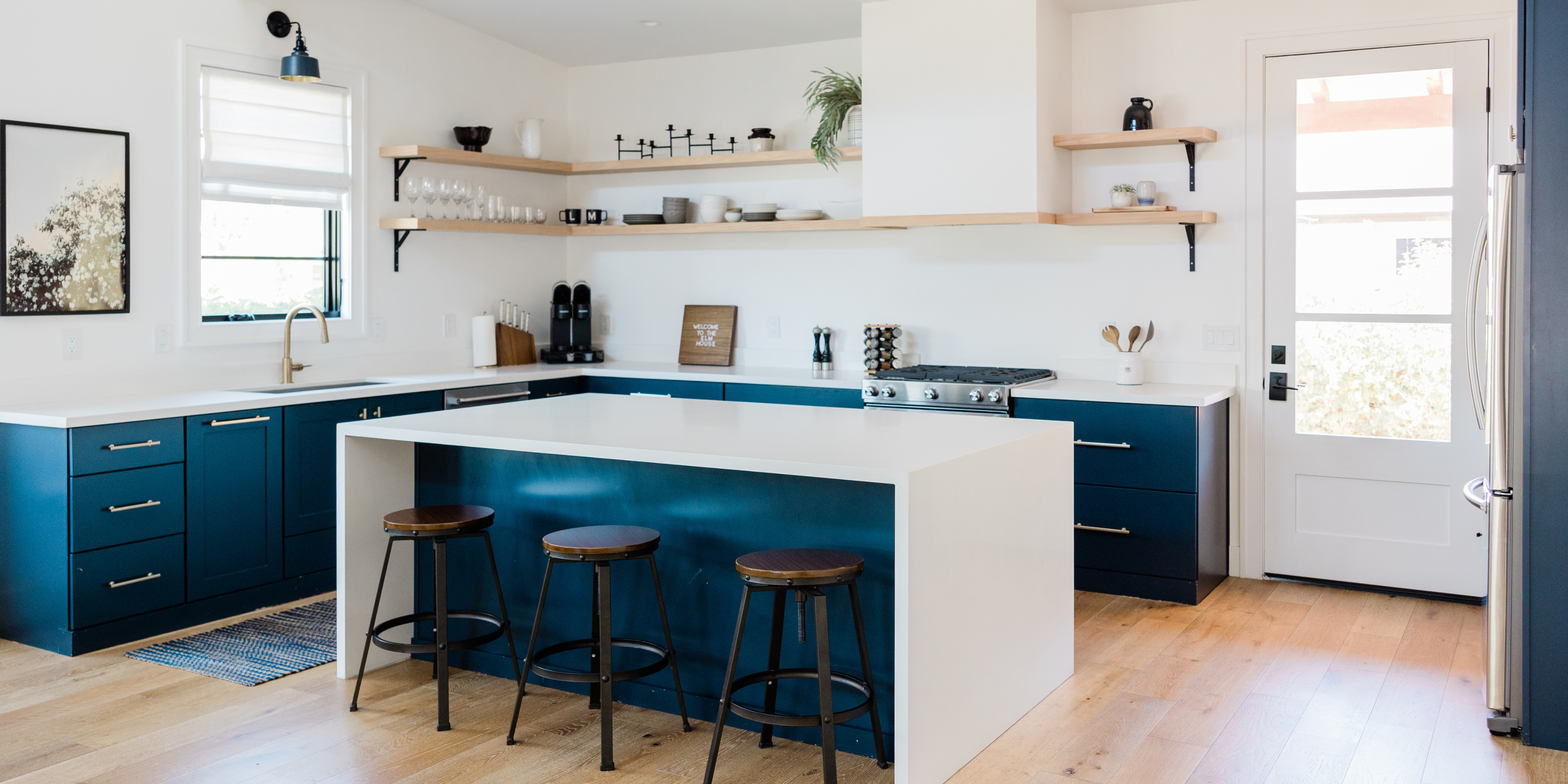 A white and blue kitchen with rustic open shelving.